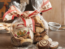 selbstgemachte Plätzchen mit Geschenksticker als Wichtelgeschenk verpacken